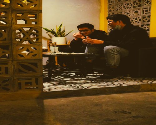 Dos personas platicando tranquilamente tomando un café